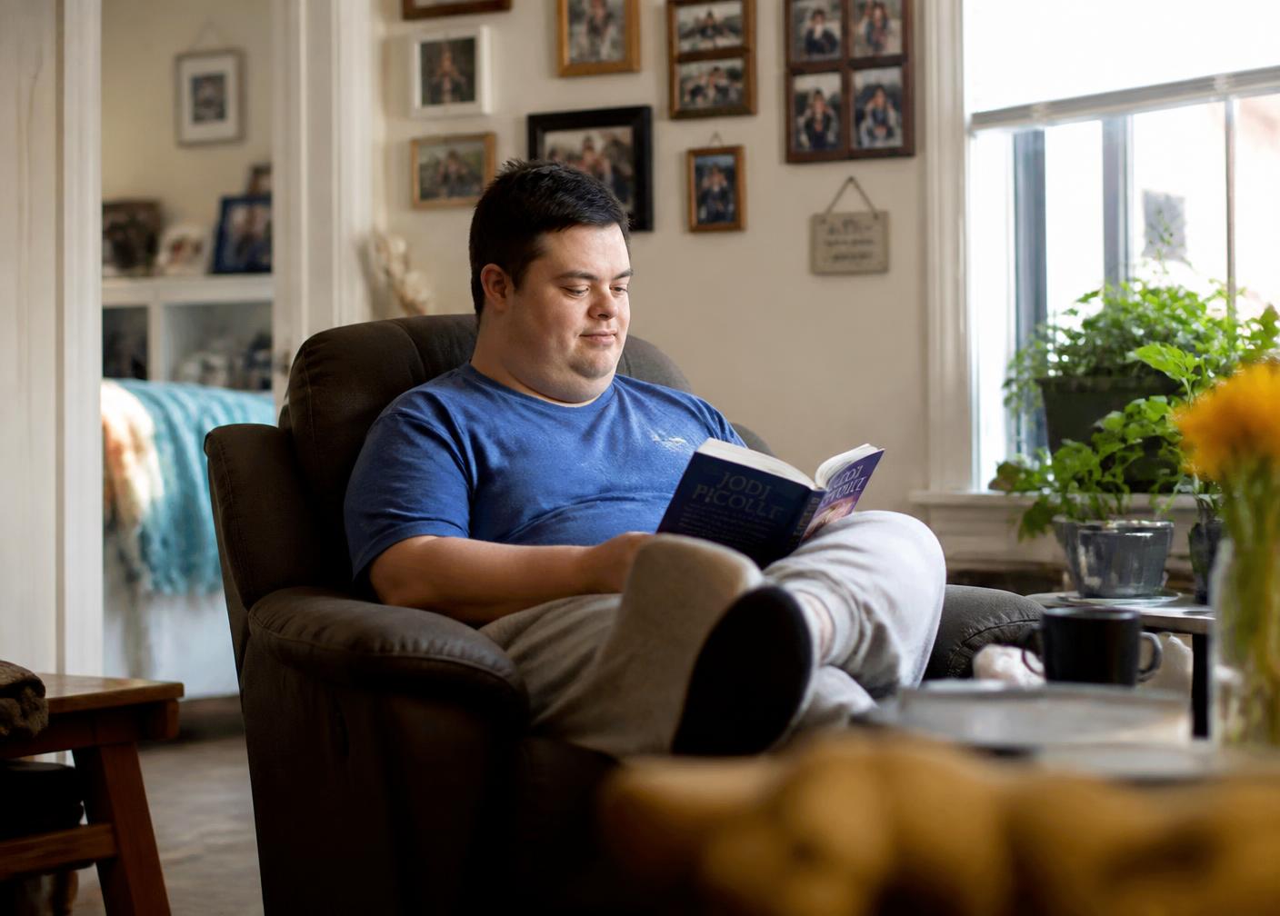 A man relaxing and reading in his own apartment